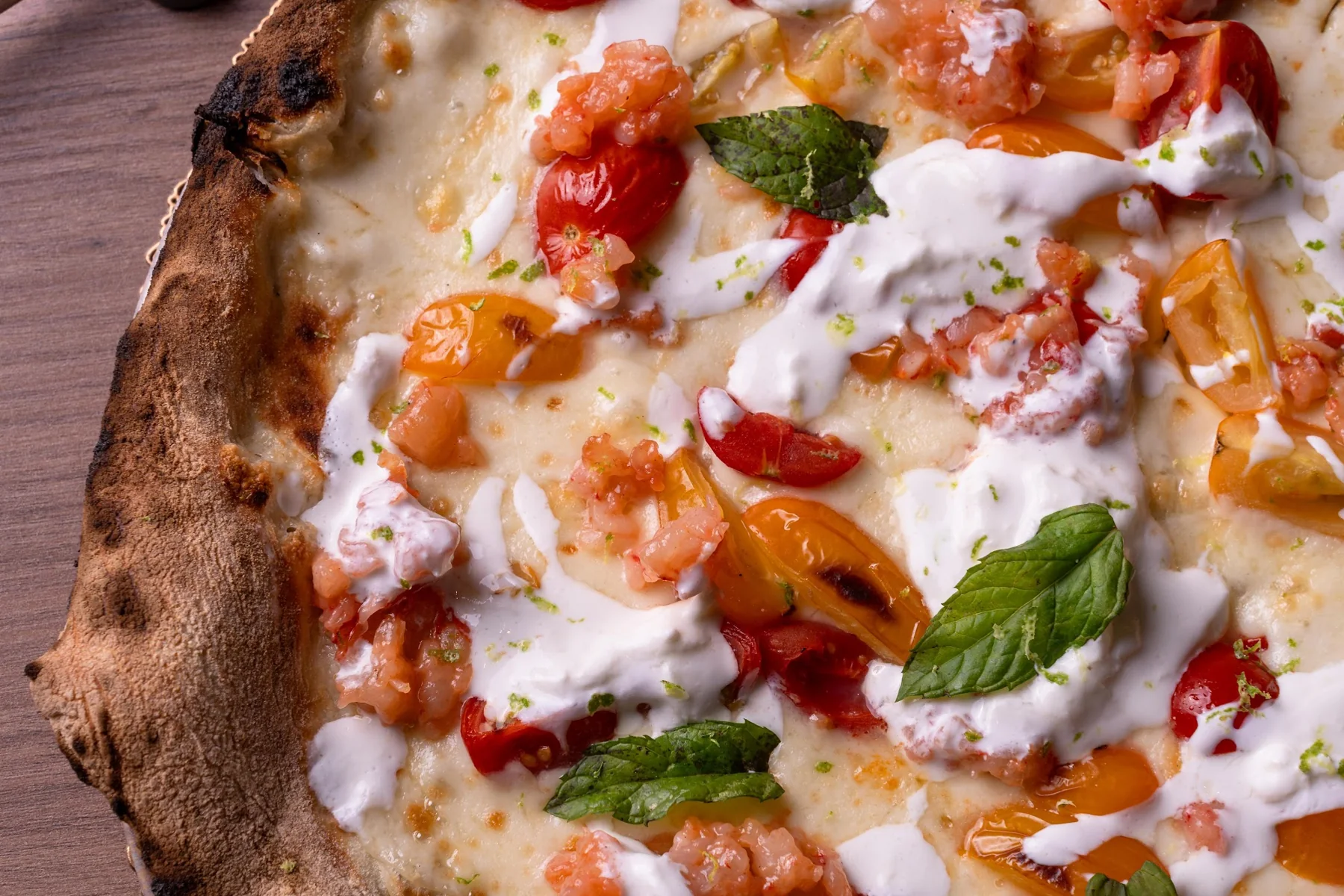Dettaglio della pizza Rogà con pomodorini e basilico
